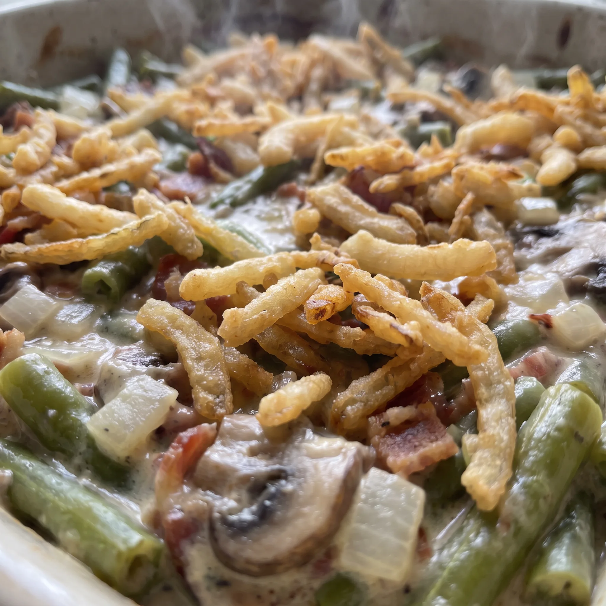 Crisp golden French fried onions over melted Monterey Jack cheese, with bacon pieces and mushrooms among green beans.
